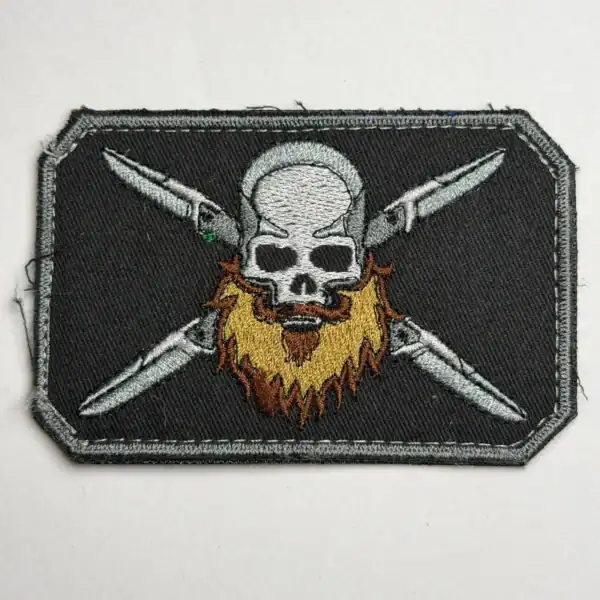 Russian pirate beard trophy patch with skull and crossed knives embroidered on dark textile