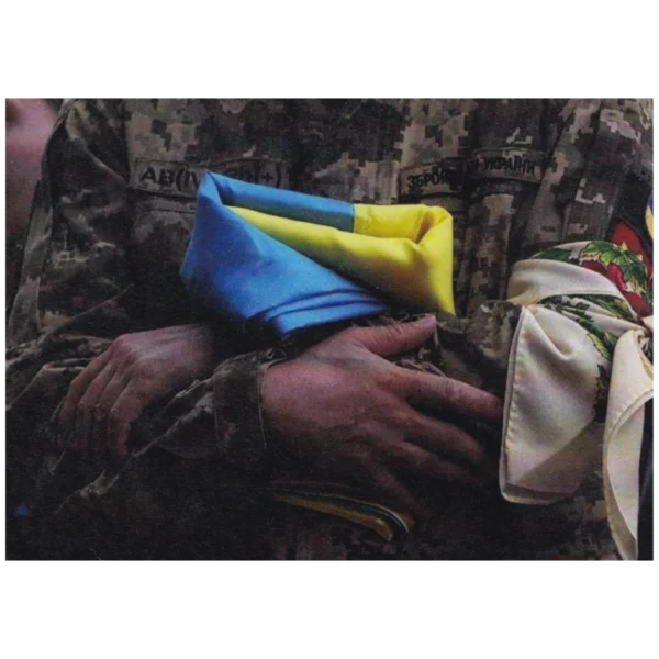 Russian Funeral Propaganda Leaflet showing a folded Ukrainian flag over a serviceman’s hands and a blue-yellow surrender warning from the Russia–Ukraine conflict.