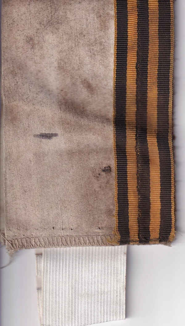Russian St George Ribbon Armband with black-and-orange ribbon sewn to a light textile band, visible field wear, staining, and trophy provenance from Ukraine.