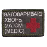 Russian Medic Profanity Patch – Combat-Worn Trophy 3 Russian Medic Profanity Patch with red medical cross, white Cyrillic text, olive fabric, combat-worn condition, and trophy provenance from the Russia–Ukraine conflict.