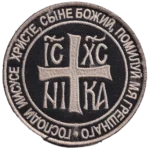 Russian Orthodox Jesus Prayer Patch – IC XC NIKA Combatant Chevron 6 Russian Orthodox Jesus Prayer Patch with silver-grey cross, IC XC NIKA Christogram, Church Slavonic inscription, black textile field, and circular embroidered border.