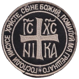 Home 29 Russian Orthodox Jesus Prayer Patch with silver-grey cross, IC XC NIKA Christogram, Church Slavonic inscription, black textile field, and circular embroidered border.