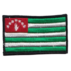 Home 20 Abkhazia Flag Patch with green and white stripes, red canton, open white hand, seven stars, black embroidered border, and rectangular format.