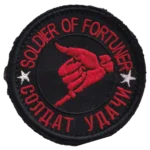 Russian Soldier of Fortune Patch with bilingual red lettering, white stars, a dagger held in a clenched hand, black fabric, and hook-and-loop backing.