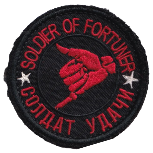 Russian Soldier of Fortune Patch with bilingual red lettering, white stars, a dagger held in a clenched hand, black fabric, and hook-and-loop backing.